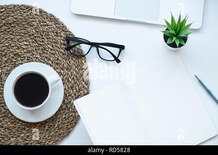 Ansicht von oben Arbeitsbereich mit Laptop, Pflanze, Tasse Kaffee, Notebooks, Pen und Gläser Stockfoto