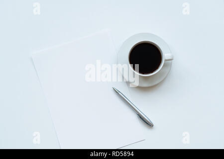 Tasse Kaffee, Stück Papier und Stift auf den Tisch. Ansicht von oben Stockfoto