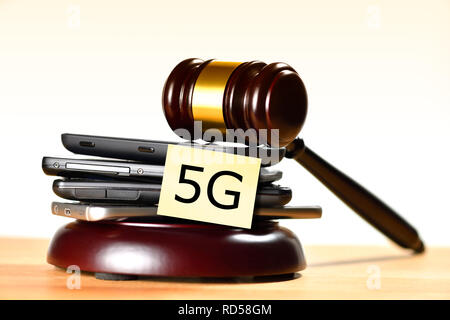 Smartphones und Hammer, 5G-Frequenzen versteigern Stockfoto