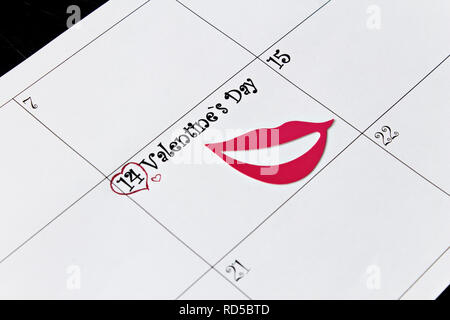 Kalender Seite mit Lippen am 14. Februar, dem Valentinstag, auf einem schwarzen Hintergrund. Valentinstag Grusskarten. Stockfoto