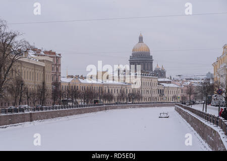 Stein Böschungen aus moyka River mit malerischen Villen und goldenen Kuppel der St. Isaak Kathedrale im Hintergrund. Winter mit Schnee. Saint Petersburg, Stockfoto