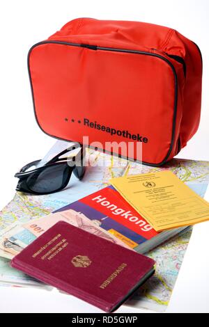 Erste-hilfe-Kit, Reisepass, Impfpass, Sonnenbrille, Reiseführer Stockfoto