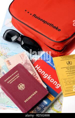 Erste-hilfe-Kit, Reisepass, Impfpass, Sonnenbrille, Reiseführer Stockfoto