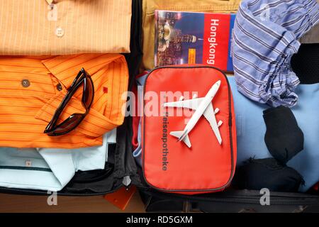 Urlaub koffer, Erste-Hilfe-Kasten, Reiseführer, Sonnenbrille Stockfoto