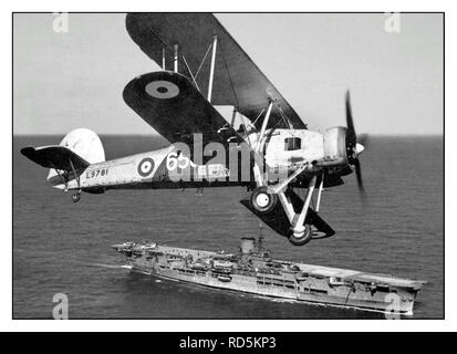 Der Torpedobomber „Schwertfisch I“ aus dem 820. Geschwader fliegt über dem Flugzeugträger „Ark Royal“ 1939. Der Torpedobomber „Fairey Swordfish“ der Luftgruppe „Ark Royal“ ging in die Geschichte ein und attackierte mit Torpedo das deutsche Nazi Kriegsmarine Bismarck Taschenschlachtschiff, an dem die Ruder nach einem Torpedoschlag feststeckten. Das Kriegsschiff konnte sich nicht zurückziehen und wurde schließlich durch einen intensiven Artilleriekampf gegen britische Marineschiffe überfordert und versenkt. Hitler hat keine Kapitulation angeordnet. Stockfoto