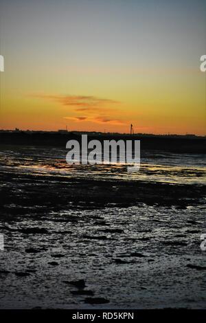 Sonnenuntergang über den schlammigen Flussmündung Vorland Stockfoto