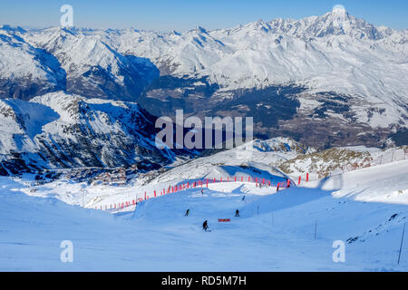 Skifahrer und Snowboarder auf den Schwarzen vom Gipfel der Aiguille Rouge, Les Arcs. Mont Blanc im Hintergrund. Stockfoto