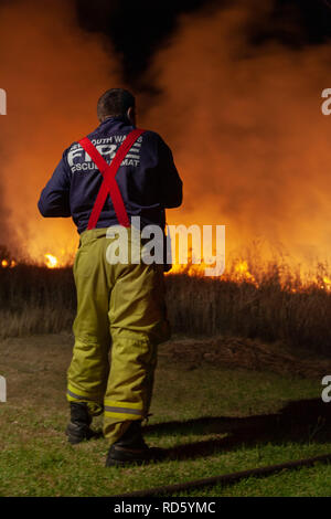 Teralba, NSW/Australien - Oktober 24, 2012: in der Nähe von Feuerwehrmann Überwachung der backburning und Löschmittel ein wildfire Gras und Bushfire zu schützen. Stockfoto