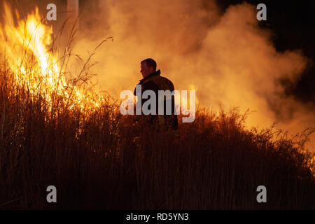 Teralba, NSW/Australien - Oktober 24, 2012: Feuerwehrmann oder Feuerwehrmann backburning und Löschmittel ein wildfire Gras und bushfire Bewohner zu schützen. Stockfoto