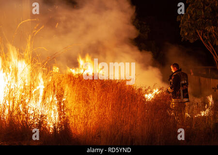 Teralba, NSW/Australien - Oktober 24, 2012: Feuerwehrmann oder Feuerwehrmann backburning und Löschmittel ein wildfire Gras und bushfire Bewohner zu schützen. Stockfoto