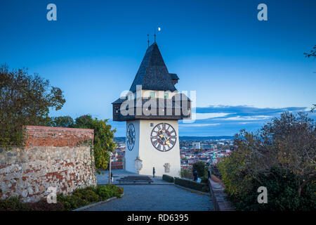 Schöne Dämmerung Blick auf berühmte Grazer Uhrturm (Uhrturm) während der Blauen Stunde in der Dämmerung, Graz, Steiermark, Österreich Stockfoto