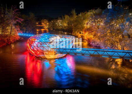 Schöne Panorama der berühmten Grazer Murinsel, eine künstliche schwimmende Insel in der Mitte der Mur bei Nacht beleuchtet, Graz, Steiermark, Stockfoto