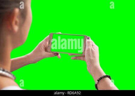 Mädchen schauen Sie ein Video oder ein Spiel auf einem Mobiltelefon. Chroma Key isoliert. Stockfoto