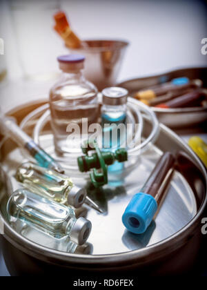 Mehrere Durchstechflaschen und Blutprobe in einem Metallauflagefach, konzeptionelle Bild Stockfoto