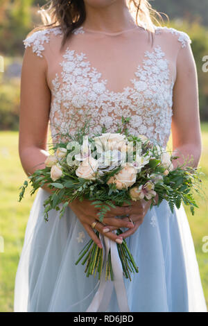 Die Braut hält einen rustikalen Wedding Bouquet mit Sukkulenten Blumen und Grün Stockfoto