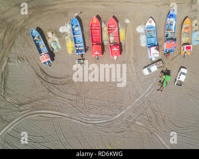 Eine Luftaufnahme direkt oberhalb der Fischerboote in den Sand, während ein Kran versuchen, vom Sand zum Meer die niedliche Fischerboote ziehen Stockfoto