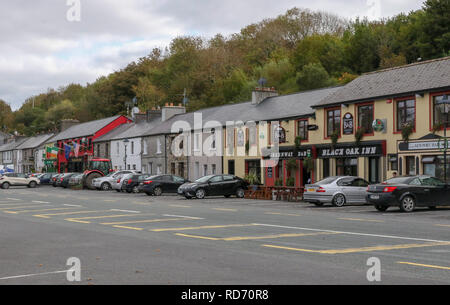 Parkende Autos auf der Straße außerhalb von Gebäuden und Häusern in Irland am Newport, County Mayo, Irland. Stockfoto