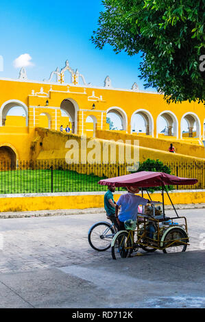 IZAMAL, Yucatan/Mexiko - 10. NOVEMBER 2018: Straße Verkäufer auf seinem Dreirad vor dem Kloster von Izamal, die gelbe Stadt namens Stockfoto