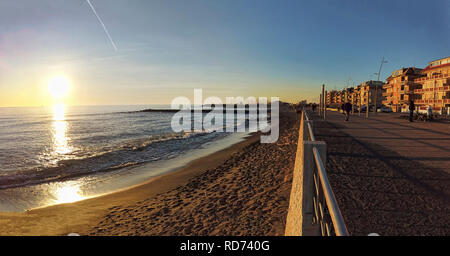 Rom Ostia Lido, Italien - Januar 15, 2019 :: Römische Küste street view in Ostia Lido bei Sonnenuntergang Zeit mit Menschen zu Fuß und den schönen Wintertag genießen Stockfoto