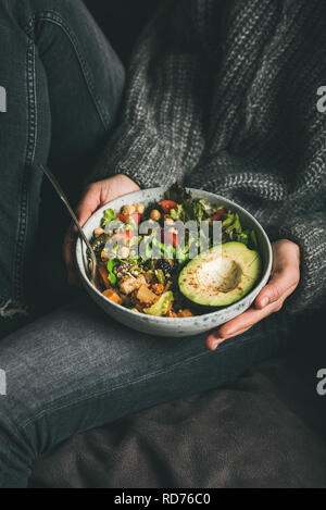 Frau mit Schale mit frischem Salat, Avocado, Bohnen und Gemüse Stockfoto