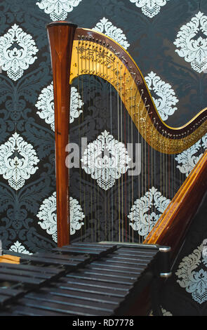 Harfe und Musikinstrumente. Dunkle Hintergrund im viktorianischen Stil. Klassische Musik und Kunst Konzept. Stockfoto