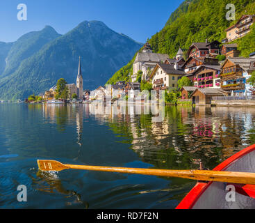 Malerische Postkarte Blick auf berühmte Hallstatt Lakeside Village in den österreichischen Alpen mit traditionellen hölzernen Ruderboot im schönen Morgen Licht Stockfoto