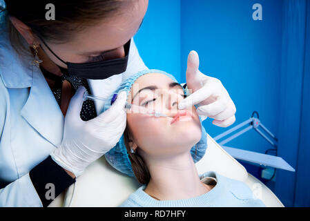 Eine junge Frau erhält Injektion in die Lippen. Schönheit Injektionen und Kosmetologie. Plastische und Ästhetische Chirurgie. Stockfoto