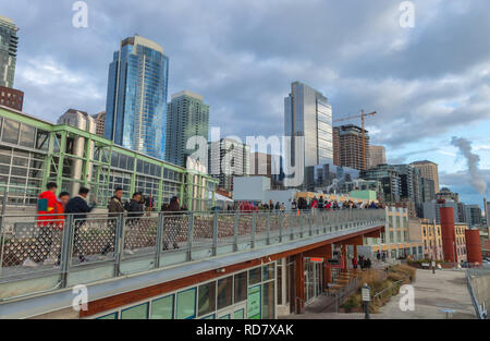 Ansicht Deck hinter den Pike Place Markt mit Touristen mit Blick auf die Elliot Bay, gefüllt mit Downtown Seattle im Hintergrund, Washington, United States. Stockfoto