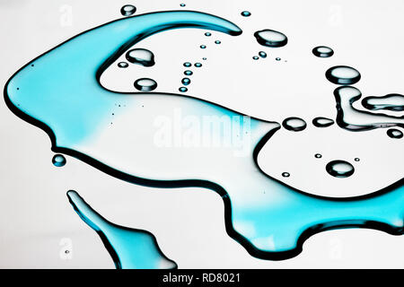 Schließen Sie herauf Bild von Verschüttetem blaue Flüssigkeit auf weißem Hintergrund Stockfoto