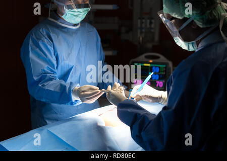 Asiatische Arzt und einem Assistenten im Operationssaal für chirurgische venöse Gefäßchirurgie Klinik im Krankenhaus. Stockfoto