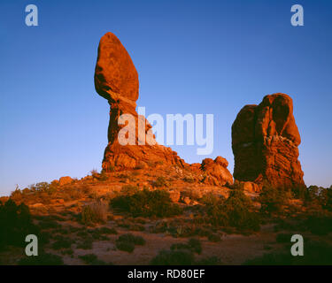 USA, Utah, Arches National Park, Sonnenuntergang auf der Balanced Rock, die von der Erosion von Entrada Sandstein gebildet wird. Stockfoto