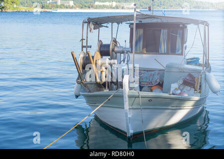 Kleine weiße überladenen Fischerboot neben dem Dock verankert. Stockfoto