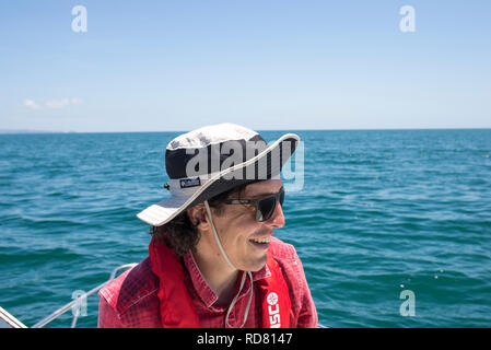 Mann in Hut und Sun-Glas Angeln auf Boot mit Schwimmweste Stockfoto