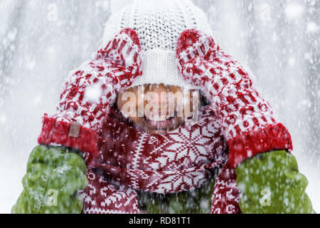 Nahaufnahme, Ansicht von lächelnden afrikanische amerikanische Kind mit Strickmütze zog über Augen bei Schneefall Stockfoto