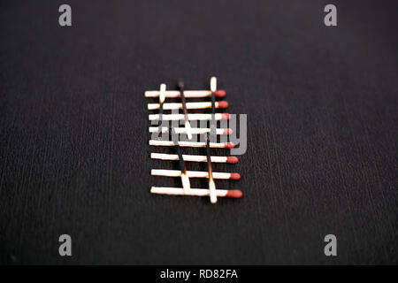 Bild der verbrannten Streichholz und roten Kopf Streichholz. Auf dem schwarzen Hintergrund isoliert. Stockfoto