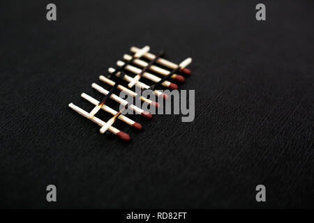 Portrait von verbrannten Streichholz und roten Kopf Streichholz. Auf dem schwarzen Hintergrund isoliert. Stockfoto