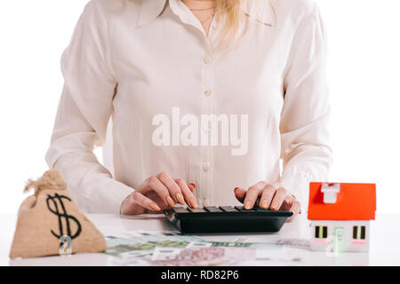 7/8-Ansicht von geschäftsfrau mit Taschenrechner auf Weiß, Hypothek Konzept isoliert Stockfoto