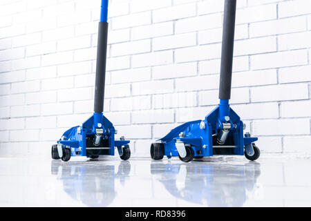 Hydraulische auto Wagenheber ab. Auto heben. Blaue Hydraulische Wagenheber für Auto reparieren. Zusätzliche Sicherheitsmaßnahmen. Auto Service station Stockfoto