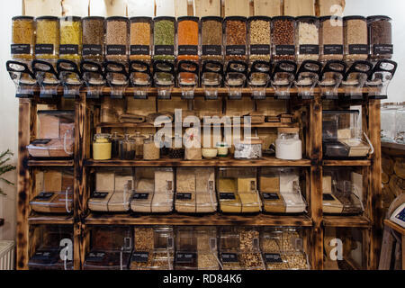 Vorderansicht der Vielzahl von Samen und Nüsse in Lebensmittelgeschäft angezeigt. Null Abfall einkaufen - Regal mit Gläsern voller Trockenfutter in organischen Shop. Stockfoto