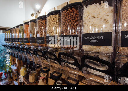Seitenansicht von rohen Lebensmitteln in Lebensmittelgeschäft angezeigt. Null Abfall einkaufen - Regal mit Gläsern voller Nüsse und Samen in der organischen Shop. Stockfoto