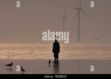 Sir Antony Gormley gemeißelte Figur, mit Flügeltüren und Windkraftanlagen, einen anderen Ort. Stockfoto