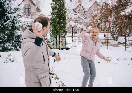 Freundliche Paar spielen mit Schneebällen im Winter Stockfoto