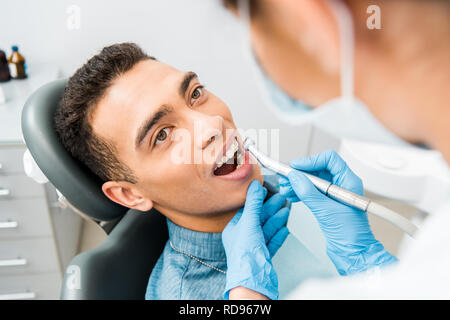 Weiblichen Zahnarzt bohren Zähne der stattlichen Afrikanische amerikanische Patienten Stockfoto