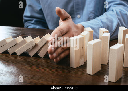 7/8-Ansicht des Menschen verhindern, Holzklötze auf Schreibtisch Stockfoto