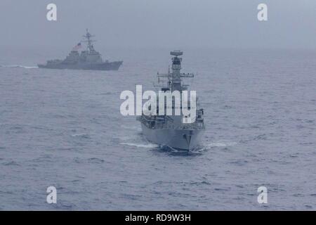 190112-N-WK 982-1420 SOUTH CHINA SEA (Jan. 15, 2018) Der Arleigh-burke-Klasse geführte Anti-raketen-Zerstörer USS McCampbell (DDG85) und die Royal Navy Typ 23 'Duke' Klasse geführte Anti-raketen-Fregatte HMS Argyll (F231) Manöver während einer Teilanmeldung Taktik ausüben. McCampbell ist Vorwärts - in die USA 7 Flotte Bereich für Maßnahmen zur Erhöhung der Sicherheit und Stabilität in der indopazifischen Region bereitgestellt. (U.S. Marine Foto von Mass Communication Specialist 2. Klasse John Harris/Freigegeben) Stockfoto