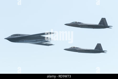 Ein US Air Force B-2 Spirit Bomber bereitgestellt von whiteman Air Force Base, Missouri, und zwei F-22 Raptors aus der 199th Fighter Squadron bei Joint Base Pearl Harbor-Hickam, Hawaii, fliegen in Formation in der Nähe von Diamond Head State Monument, Massachusetts, während einer Interoperabilität Training Mission Jan. 15, 2019. Drei B-2 Bomber und mehr als 200 Flieger hier in US-Strategic Command's Bomber task force Mission eingesetzt. Bomber aircraft regelmäßig durch die indopazifischen Region drehen Funktionen mit wichtigen regionalen Partnern zu integrieren und einen hohen Stand der Flugzeugbesatzung Kenntnisse erhalten. (U.S. Air F Stockfoto