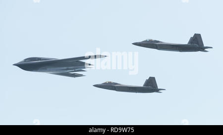 Ein US Air Force B-2 Spirit Bomber bereitgestellt von whiteman Air Force Base, Missouri, und zwei F-22 Raptors aus der 199th Fighter Squadron bei Joint Base Pearl Harbor-Hickam, Hawaii, fliegen in Formation in der Nähe von Diamond Head State Monument, Massachusetts, während einer Interoperabilität Training Mission Jan. 15, 2019. Drei B-2 Bomber und mehr als 200 Flieger hier in US-Strategic Command's Bomber task force Mission eingesetzt. Bomber aircraft regelmäßig durch die indopazifischen Region drehen Funktionen mit wichtigen regionalen Partnern zu integrieren und einen hohen Stand der Flugzeugbesatzung Kenntnisse erhalten. (U.S. Air F Stockfoto