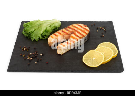 Gegrilltes Lachssteak mit Zitrone und Salat auf einem Schiefer Platte Stockfoto