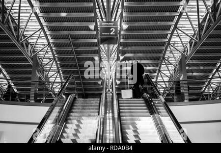 Ansicht der Rückseite des unkenntlich Geschäftsmann mit Aluminium Koffer geht in den zweiten Stock des Terminal Stockfoto