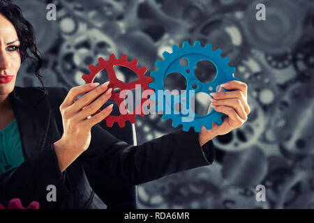 Geschäftsfrau versucht Gänge Stücke zu verbinden. Konzept der Teamarbeit, Partnerschaft und Integration Stockfoto